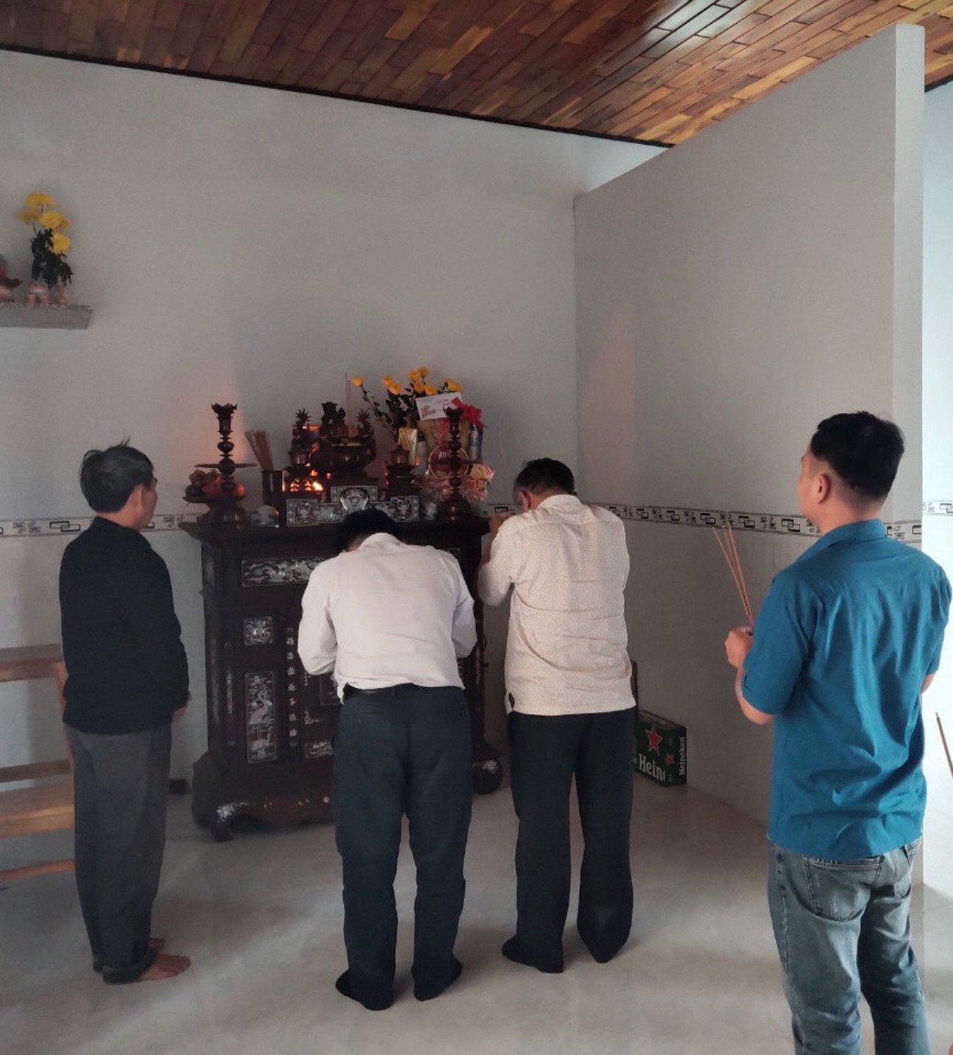 Ông Võ Hữu Thiện, Đảng ủy viên, Chánh Văn phòng Sở (bên trái), ông Đặng Thành Trưng, Đảng ủy viên, Chánh thanh tra Sở (bên phải) thắp nhang viếng Mẹ Lê Thị Thâm ở xã Phước Hòa, huyện Tuy Phước.